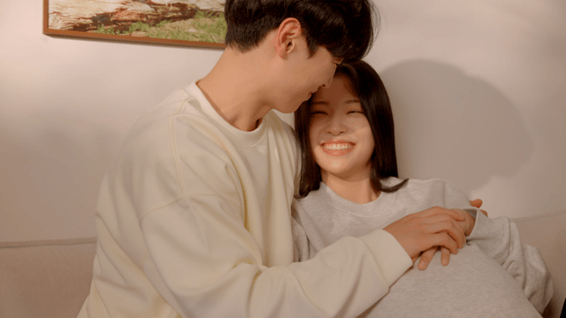 Pregnant couple sitting comfortably at home