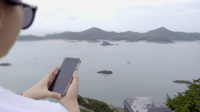 해안 경치를 사진 찍는 여성