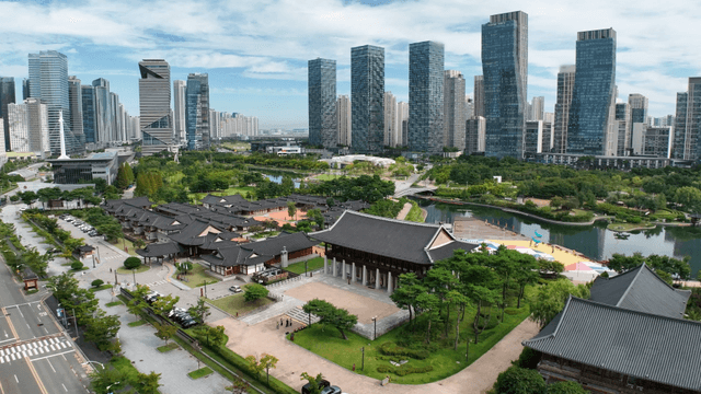 Traditional Korean house by the lake with skyscrapers in the background