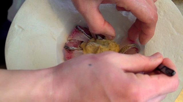 Chef preparing a dish with fish and puree