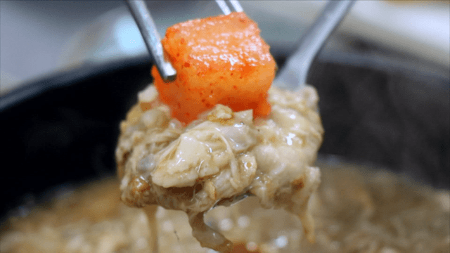 Spoon with phellinus linteus ginseng chicken soup porridge and kkakdugi