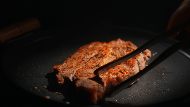Steak sizzling on a hot pan