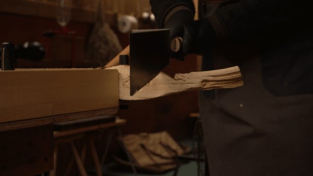 Woodcraft artisan sawing wood pieces in a cozy workshop