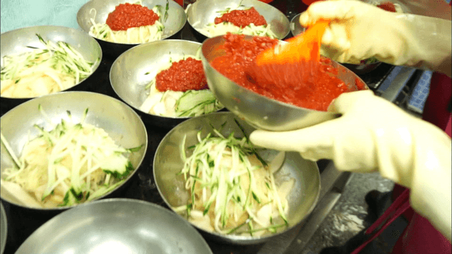 Preparing Korean wheat noodles with sauce