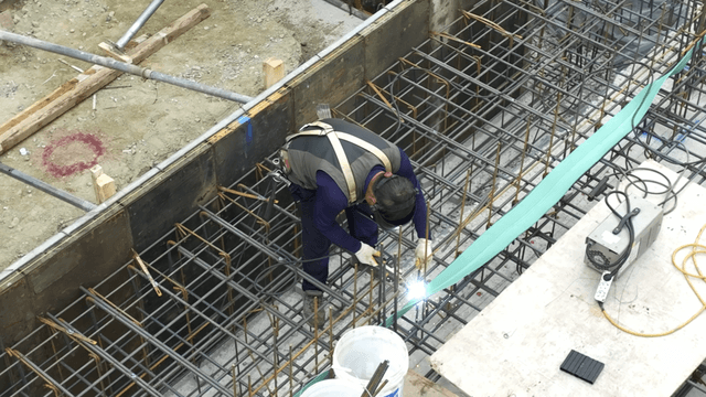 Construction worker welding steel bars