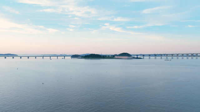 Calm sea with a distant bridge