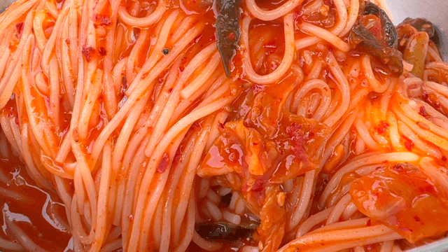 Kimchi bibim noodles and side dishes on the table