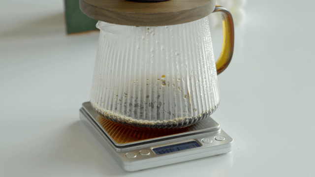 Coffee brewing in a glass carafe on a scale