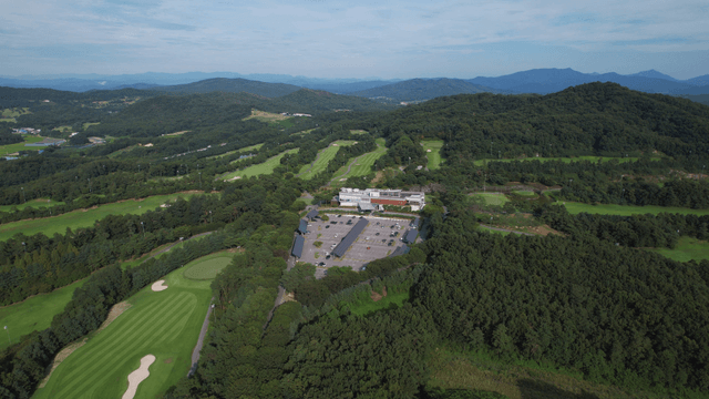 Aerial view of a golf course surrounded by lush forests