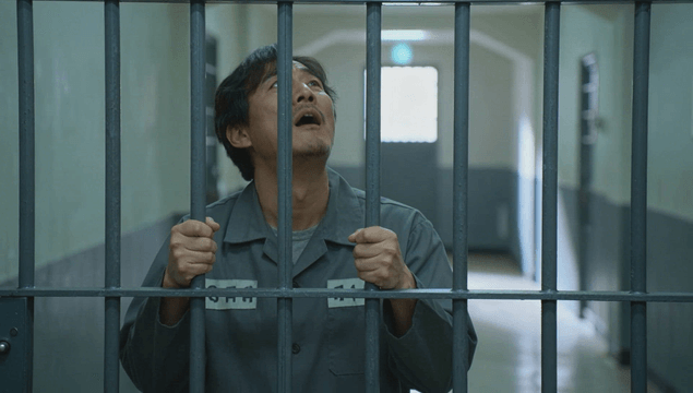 Male prisoner shouting while gripping jail bars
