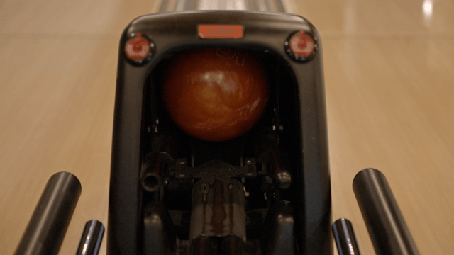 Bowling ball emerging at the bowling alley