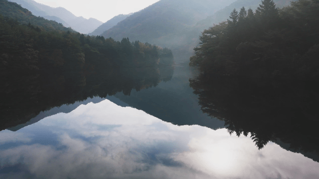 Tranquil lake surrounded by misty mountains
