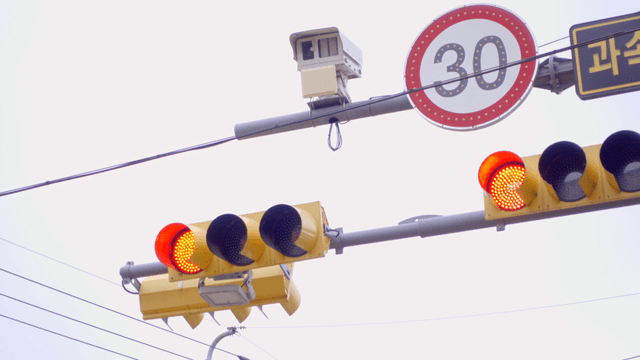 빨간 불이 깜빡이는 신호등과 속도 제한 표지판