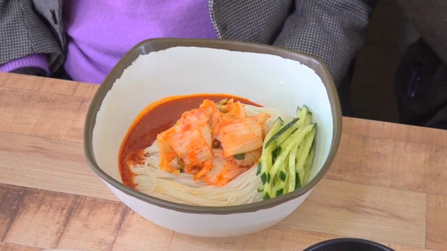 Spicy noodles with cucumber slices and Kimchi