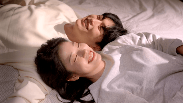 Smiling couple playing on bed