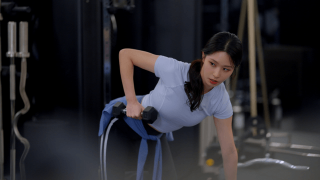 Young woman doing dumbbell rows