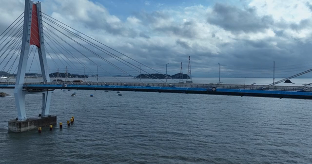 A bridge over a calm sea with islands