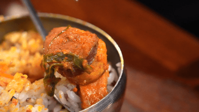 Various budaejjigae sausage pieces placed on rice bowl