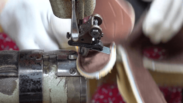 Seamstress sewing leather fabric with industrial sewing machine