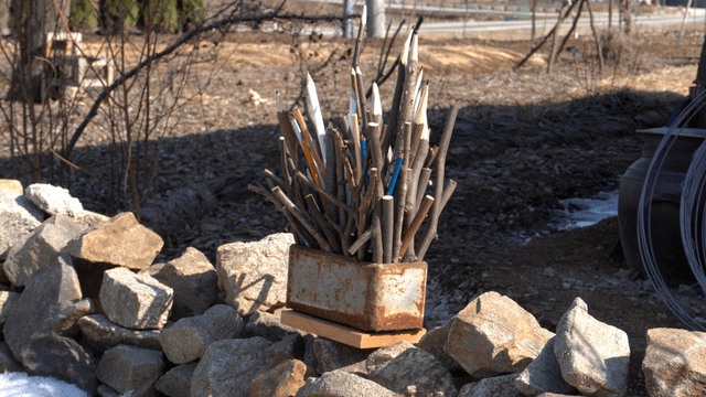 Wooden pencil sculpture placed on stone wall