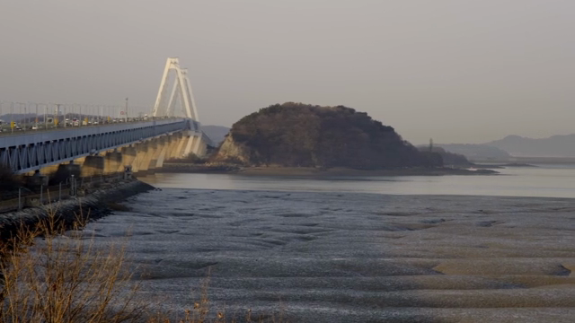 Bridge over a calm sea with distant hills