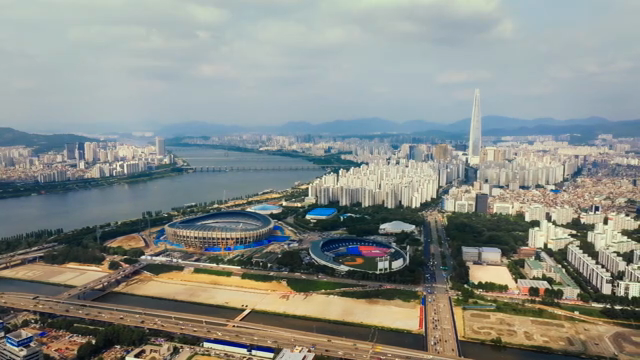 A sprawling cityscape with a river and stadiums