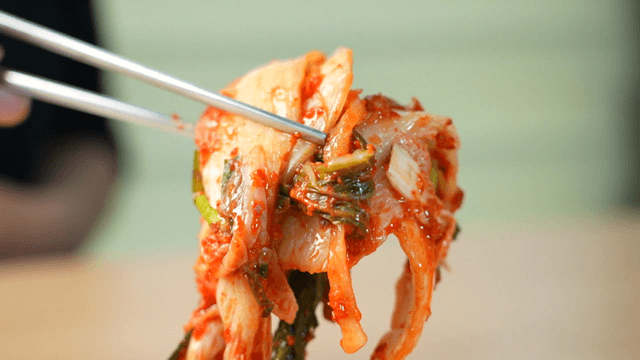 Well-fermented kimchi lifted with chopsticks