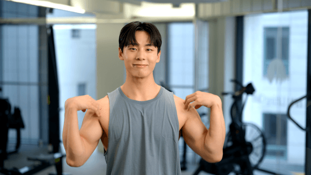 Young male warming up with arm rotations in gym
