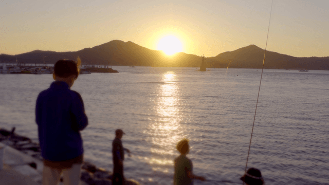 해질녘 바다에서 낚시하는 사람들