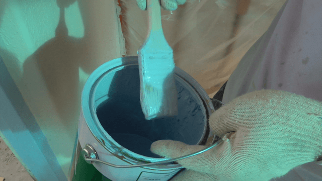 Brush delicately dipped into paint can