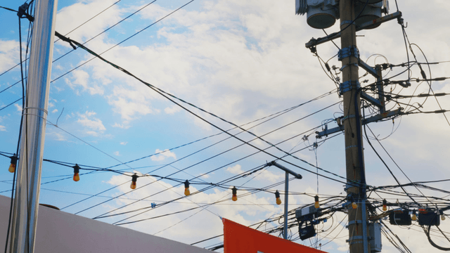 Electric poles and wires against the sky