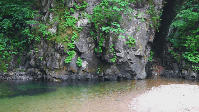 Shimmering stream beneath massive cliff