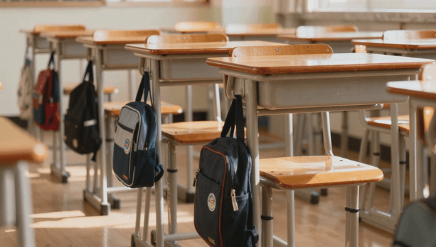 Empty classroom with desks and bags neatly arranged