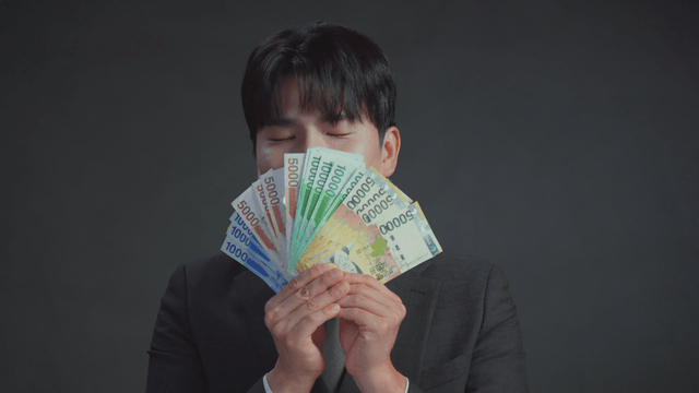 Man smelling money with a satisfied expression