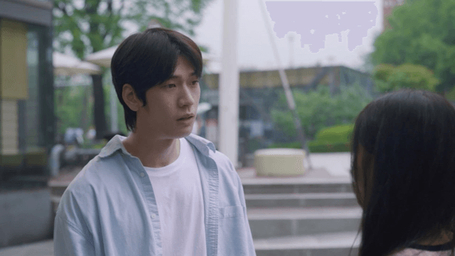 Man talking to woman in rainy park