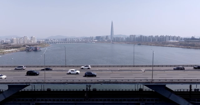 A bridge over a river with city skyline
