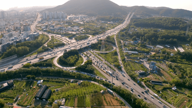 Busy highway intersection between rural fields and city