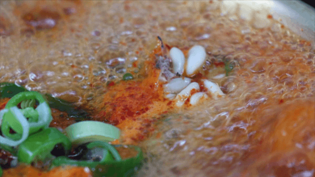 Spicy cod soup boiling with vegetables