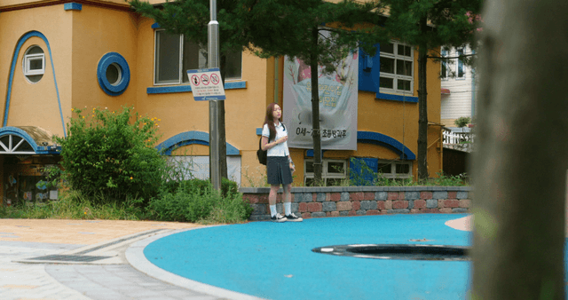 Student standing outside a colorful building