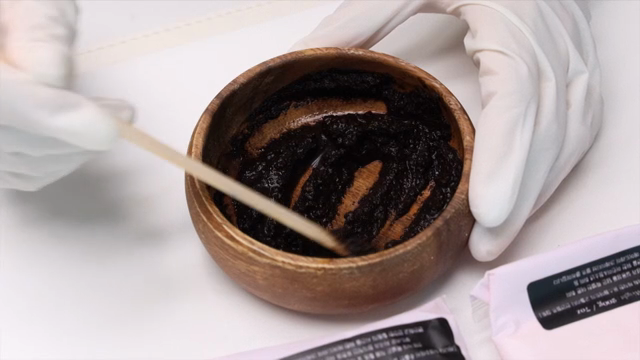 Mixing dark cosmetic paste in a bowl