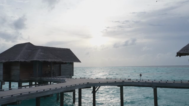 Overwater bungalows by the ocean at sunset