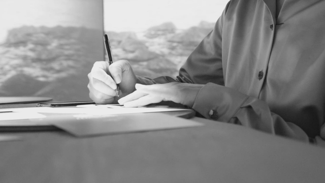 Person using a smartphone and writing