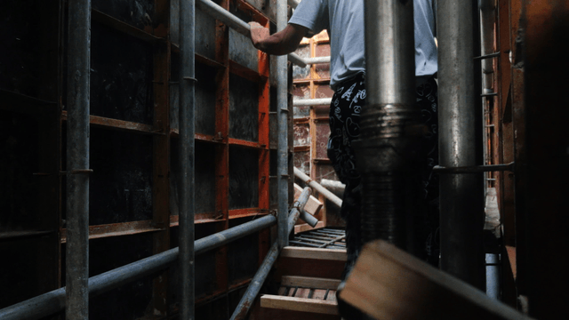Worker navigating through scaffolding