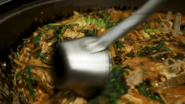 Ladle stirring pork back-bone soup