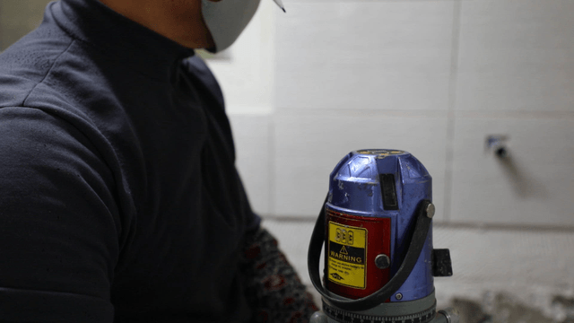 Worker using a laser level indoors