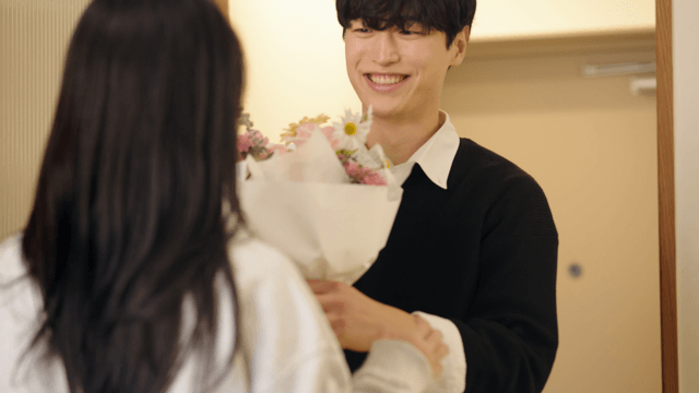 Wife greeting husband returning home with bouquet