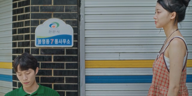 셔터가 닫힌 가게 앞에 있는 커플