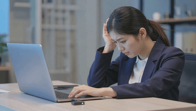 Serious office worker using laptop in workplace