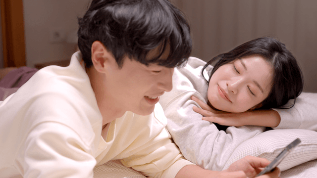 Couple spending time together on bed watching smartphone