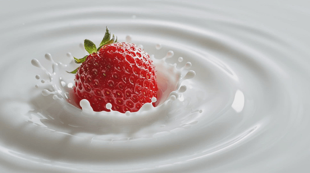 Strawberry splashing into milk